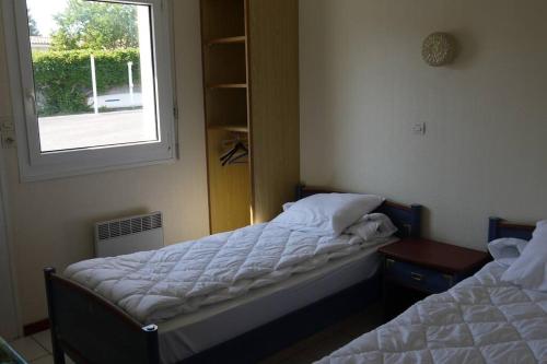 Duas camas num quarto com uma janela em Appart en front de mer pour famille : Molène em La Bernerie-en-Retz