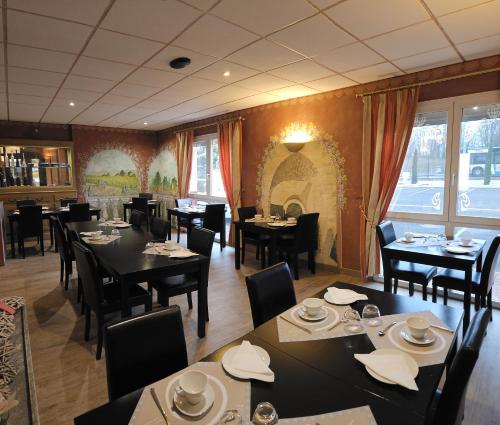 アグノーにあるHotel Restaurant Champ Alsaceのレストラン内のダイニングルーム(テーブル、椅子付)