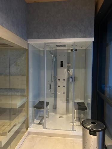 een glazen douchecabine met 2 krukken in een kamer bij B&B Veluwemeer in Biddinghuizen