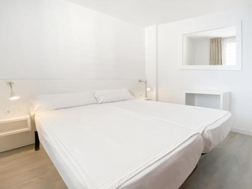 سرير أو أسرّة في غرفة في Apartamentos Morito Beach