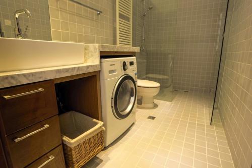 a bathroom with a washing machine and a toilet at Shanghai Lane 里弄公寓 in Shanghai