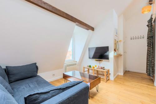 a living room with a blue couch and a tv at Charming bright flat in Vieux Lille. in Lille