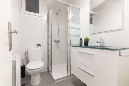 uma casa de banho branca com um WC e um chuveiro em Tetuan street apartment em Santander