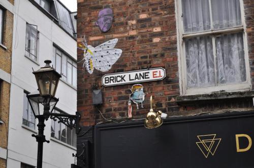 a street sign on the side of a brick building at Cosmos capsule coworking London in London