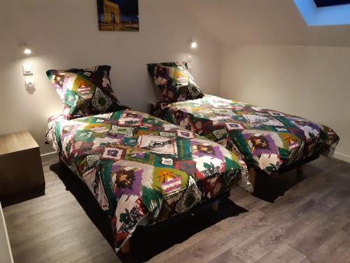 um quarto com uma cama e um edredão em à deux pas d'Etretat em Bordeaux-Saint-Clair
