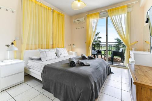 a bedroom with a large bed and a balcony at Sunny View - A Stunning Apartment With Private Rooftop in Paphos City