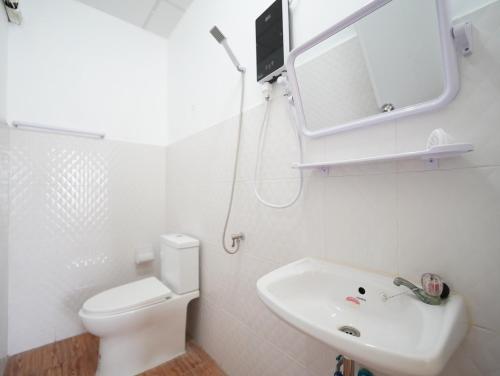 a bathroom with a toilet and a sink and a mirror at EZ Sleep @ Ratchada 19 in Bangkok