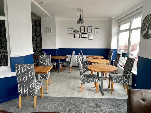 a dining room with wooden tables and chairs at The Fossil Tree Hotel in Blackpool