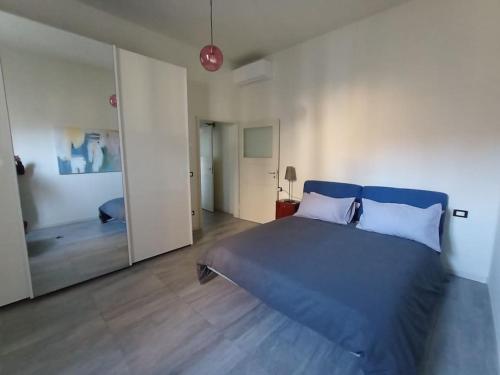 - une chambre avec un lit bleu et un grand miroir dans l'établissement L'Appartamento Storico dal Design Moderno, à Faenza