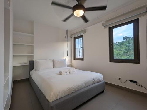 een slaapkamer met een groot wit bed en een raam bij Casa Ambar Apartments in Panama-Stad