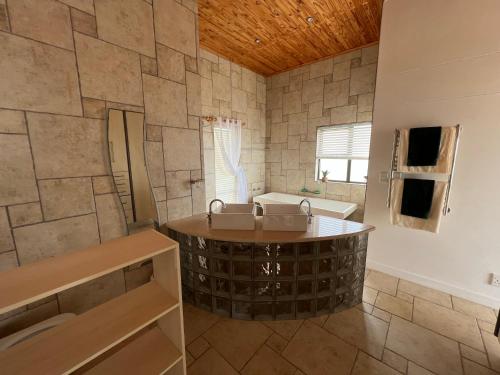 ein Badezimmer mit einer großen Badewanne und einem Waschbecken in der Unterkunft Beach House in Henties Bay