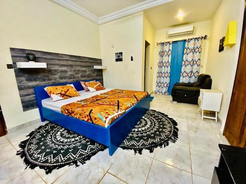 a bedroom with a blue bed and a couch at Zombré in Ouagadougou