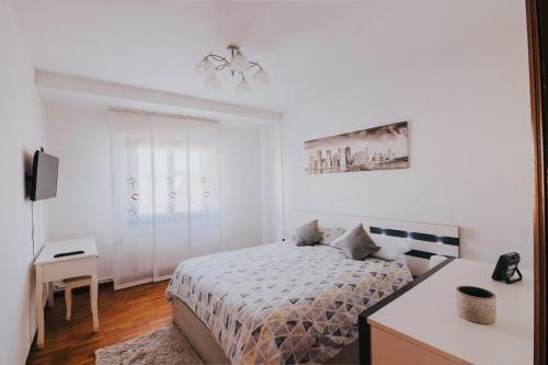- une chambre blanche avec un lit et un bureau dans l'établissement Apartamento Siervas de Jesús, à Haro