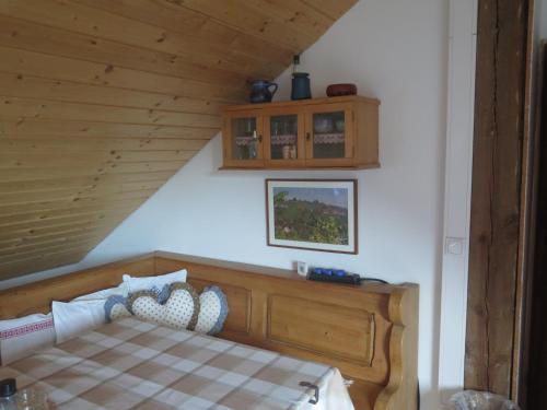een slaapkamer met een houten bed met een geruite sprei bij Landhaus Zirknitz in Sankt Stefan ob Stainz