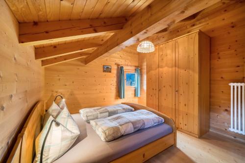 a bedroom in a log cabin with two beds at Thalhof Kornigl in Ultimo