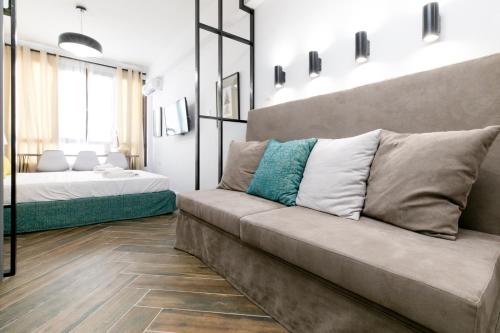 een woonkamer met een bank en een bed bij Vibrant Studio Close To Panepistimio Metro-Zaloggou str in Athene