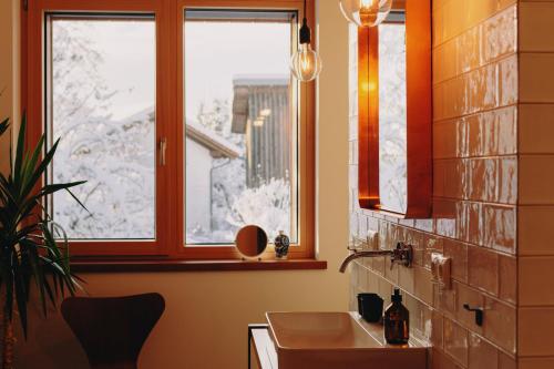La salle de bains est pourvue d'un lavabo et d'une fenêtre. dans l'établissement Ferienhaus Schmidhuber, à Chieming