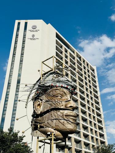 un bâtiment avec une sculpture d'un visage devant lui dans l'établissement The Trilogy Apartment MM 51011, à Pretoria