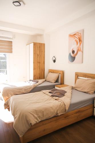 two beds in a room with white walls at Apartments Murdzoski in Struga