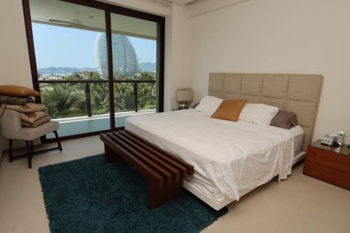 a bedroom with a large bed and a large window at Hermosa Playa en Acapulco Diamante, Isla Residence in Acapulco