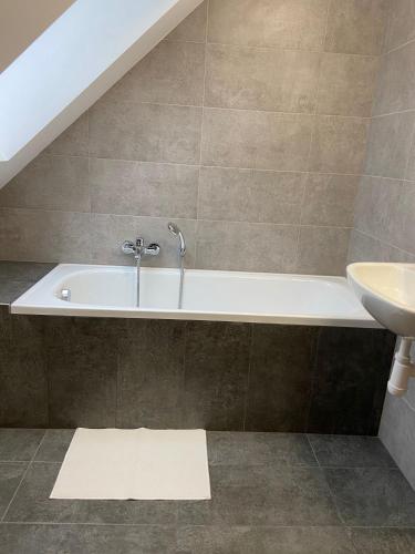 a bathroom with a bath tub and a sink at TVM Ostrava 1 in Ostrava