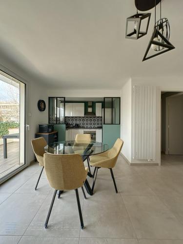 une salle à manger avec une table et des chaises en verre dans l'établissement AGENCIA appartement 2 Pièces lumineux terrasse, à Cannes