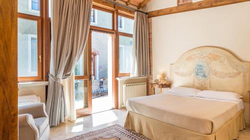 a bedroom with a bed in a room with windows at Villa Le Chiarne 22, Emma Villas in Asciano