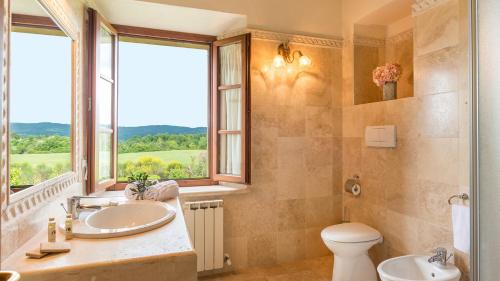 a bathroom with a sink and a toilet and a window at Villa Le Chiarne 22, Emma Villas in Asciano