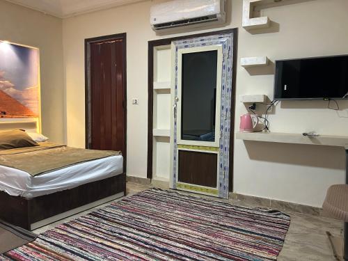 a bedroom with a bed and a tv and a mirror at Matto Pyramids Inn in Cairo