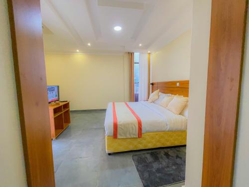 1 dormitorio con 1 cama y TV en Junior Suite at Amikus Hotel, 