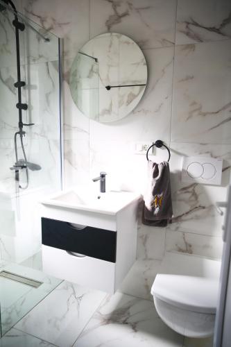a white bathroom with a sink and a toilet at Apartments Murdzoski in Struga