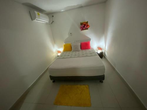 a small bedroom with a bed in a white room at posada sunrise view vacation home in Providencia