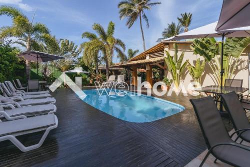 uma piscina num resort com cadeiras e um guarda-sol em Casa no Ceará a 15 min da Praia da Canoa Quebrada em Aracati
