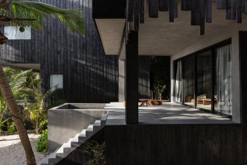 a house with a dog laying on the side of it at UMi Tulum in Tulum