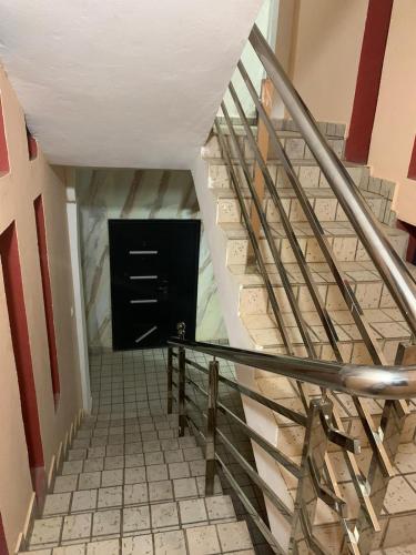 een trap met een zwarte deur in een kamer bij Bijilo Appartments in Bijilo
