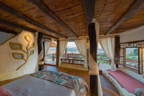 a bedroom with two beds in a room with windows at Cabaña Malaquita - Seilan Alojamiento Rural in Paipa