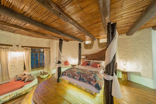a bedroom with a bed in a room with wooden ceilings at Cabaña Malaquita - Seilan Alojamiento Rural in Paipa