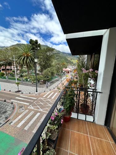 een balkon van een gebouw met planten en een straat bij Hotel Agave Baños in Baños