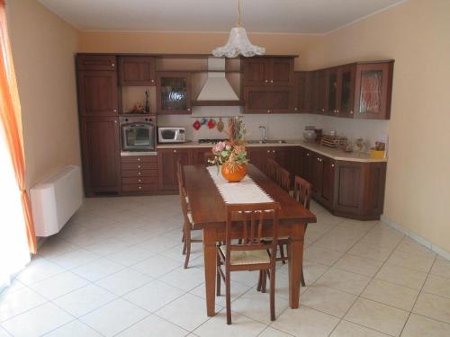 a kitchen with a wooden table with chairs and a table sidx sidx sidx at B&B Casa Piva in Serravalle