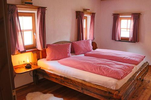 Cette chambre comprend un lit avec des oreillers rouges et blancs. dans l'établissement Manggehof, à Grosshattenberg