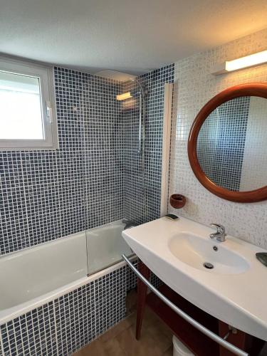 une salle de bain avec un lavabo, un miroir et une baignoire dans l'établissement MAISONS SUR LA PLAGE Joli 3 pièces mezzanine 1ère ligne vue mer Richelieu Cap d'Agde, au Cap d'Agde