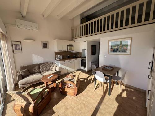 un salon avec un canapé et une table dans l'établissement MAISONS SUR LA PLAGE Joli 3 pièces mezzanine 1ère ligne vue mer Richelieu Cap d'Agde, au Cap d'Agde
