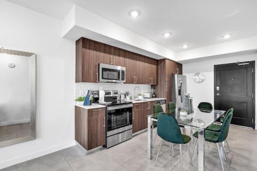 a kitchen with a table and green chairs at Gorgeous 3-Bed Retreat Mins from Bayside and Parking in Miami