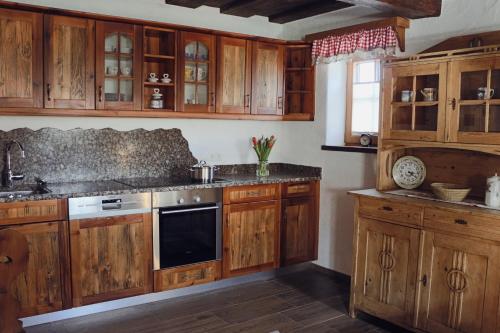 - une cuisine avec des placards en bois et une cuisinière dans l'établissement Manggehof, à Grosshattenberg