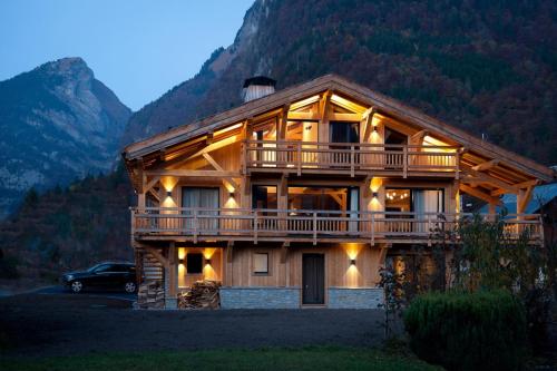 una grande casa in legno con una terrazza perimetrale di Chalet de montagne a Samoens avec jacuzzi et vue imprenable a Samoëns