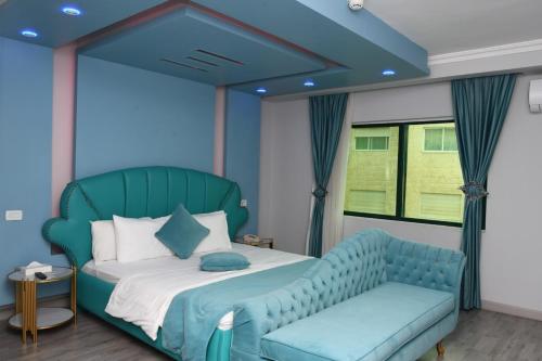 a bedroom with a blue bed and a blue couch at Sparr Hotel in Amman