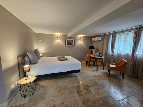 1 dormitorio con 1 cama, 1 mesa y 1 silla en La fontaine de rocoule en Rochefort-en-Valdaine