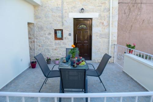 eine Terrasse mit Stühlen, einem Tisch und einer Tür in der Unterkunft The Secret Ontas, Traditional stone house in Rethymno