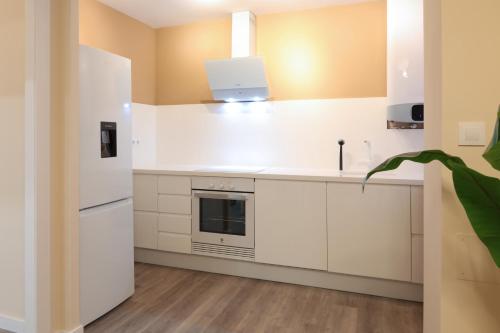 a kitchen with white cabinets and a laptop on the counter at Non Stress Nuevo Turia in Valencia