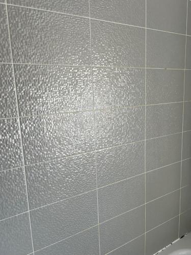 a white tiled wall in a bathroom at Central Birmingham in Birmingham
